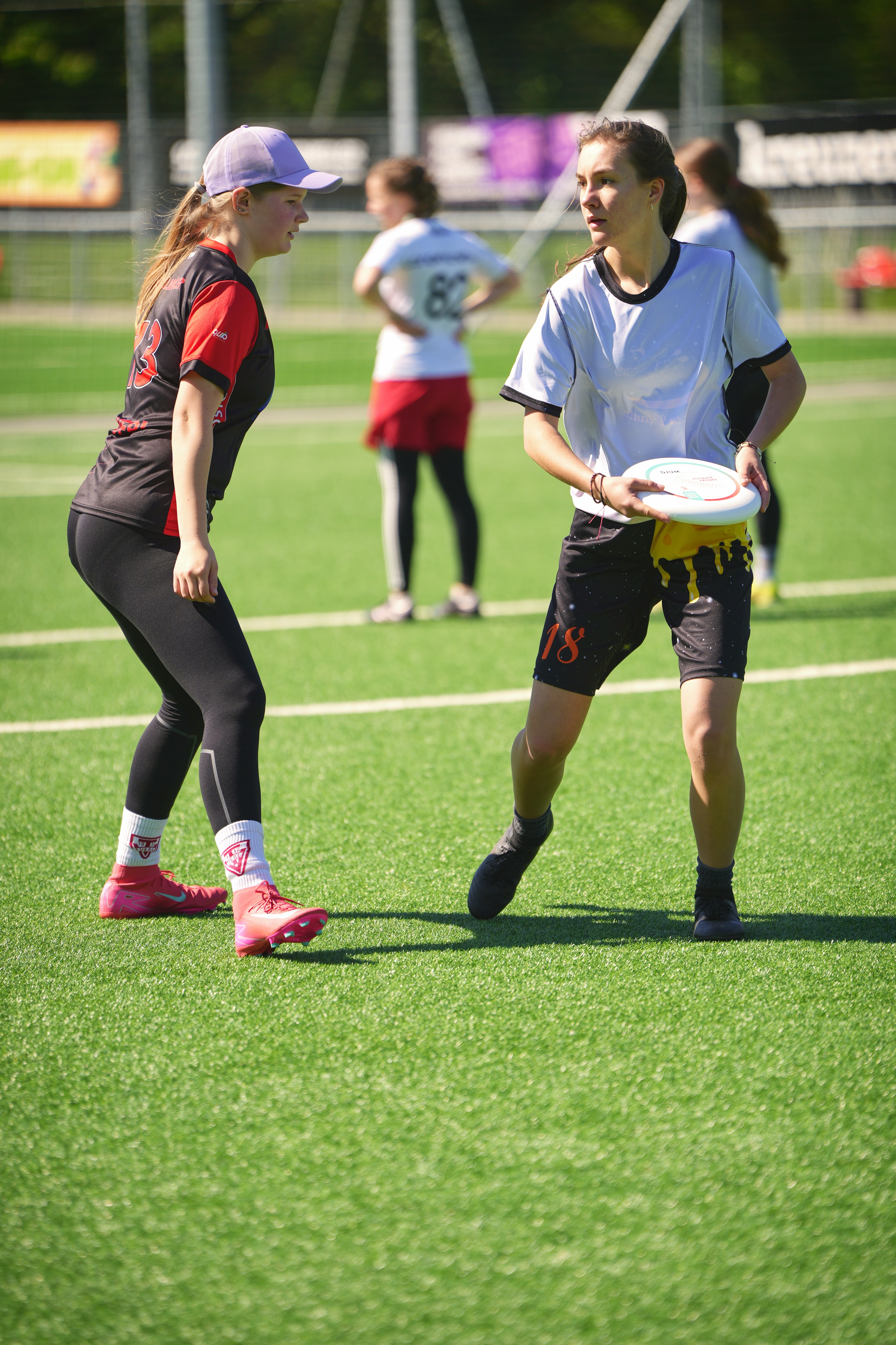 Eine Frisbee Spielerin hält eine Scheibe kurz vor dem Wurf